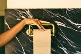 BAMBUM bamboo toilet paper on a gold holder in a dark marble bathroom